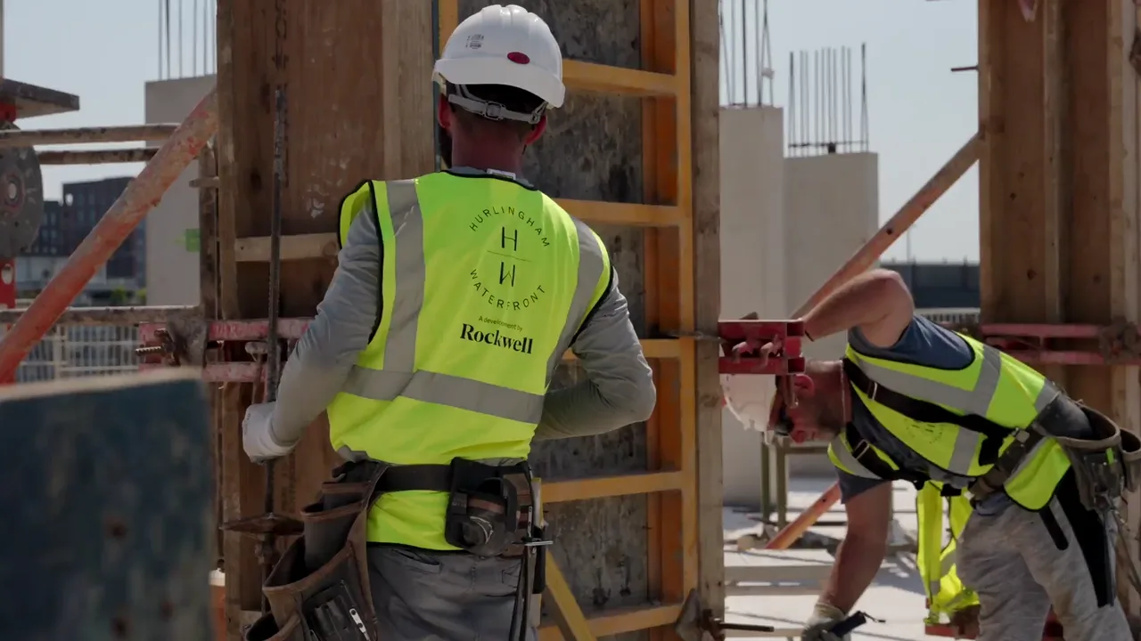 A physical Hurlingham model followed by Rockwell operatives checking plans, working on formwork and carrying materials on site