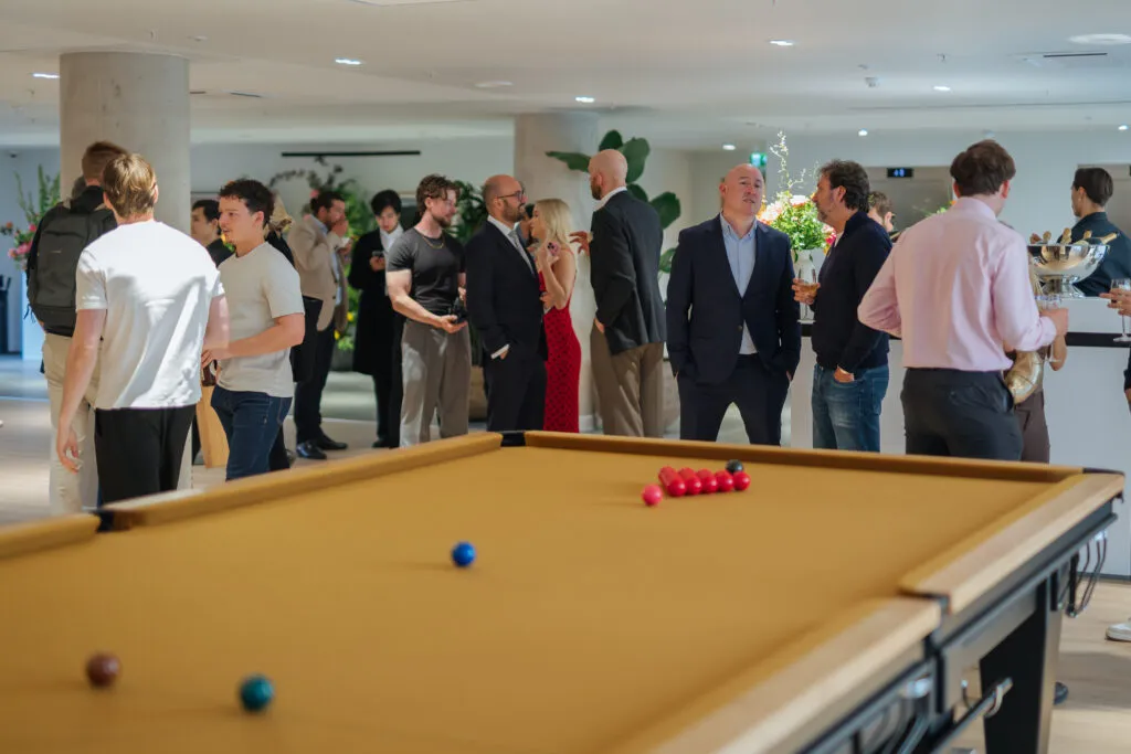 Guests gathered around a billiards table during the Herland Gardens opening celebration.